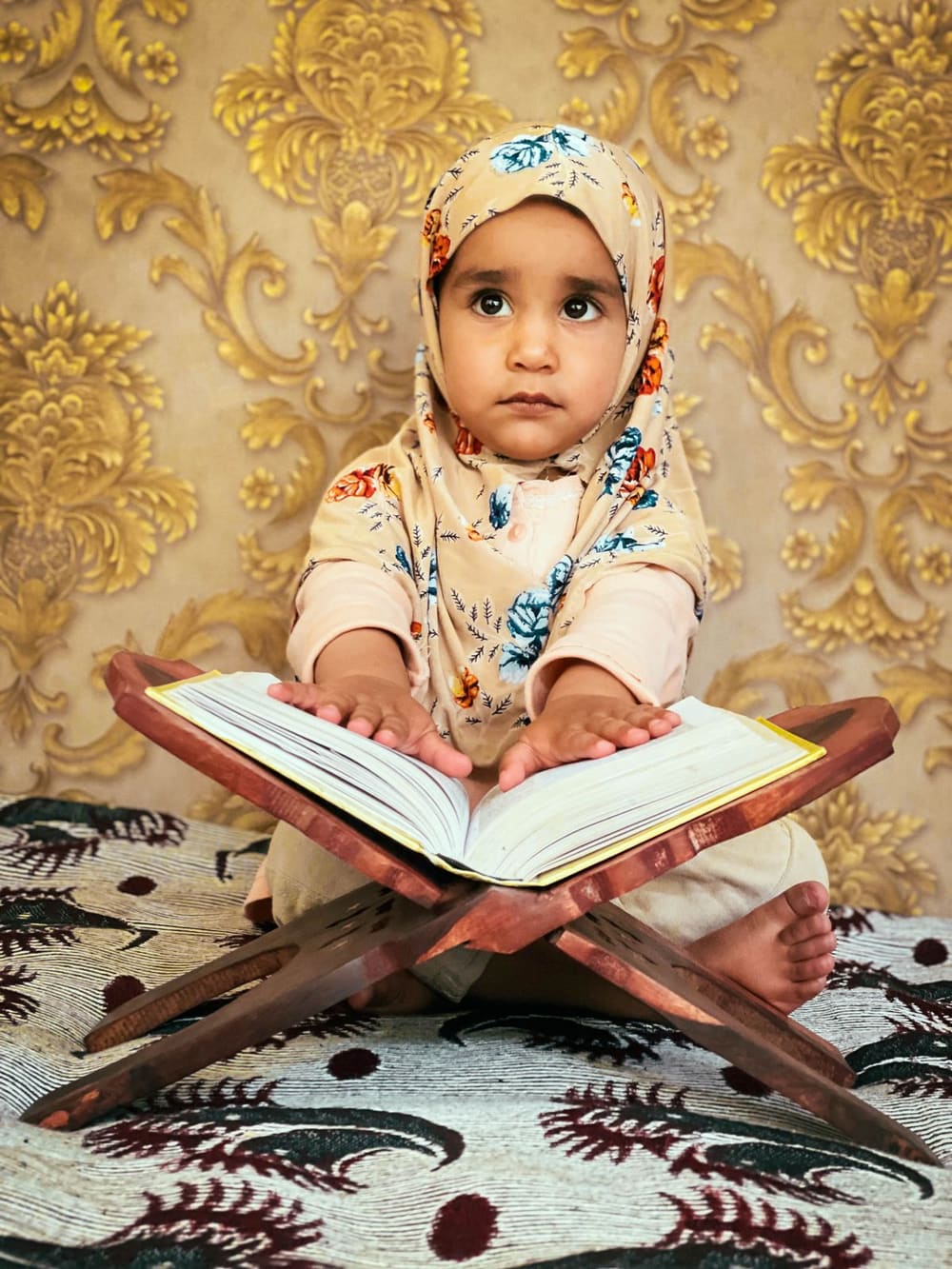 A young child reading the Qur'an on a rehal