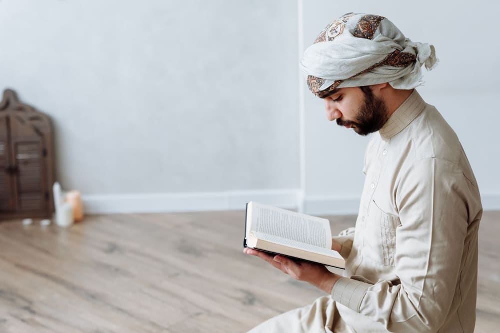 An open Qur'an resting on a wooden stand, pages turned midway