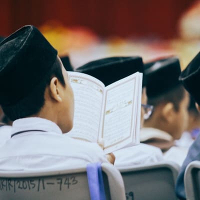A hafiz reciting from memory with the Qur'an closed before him